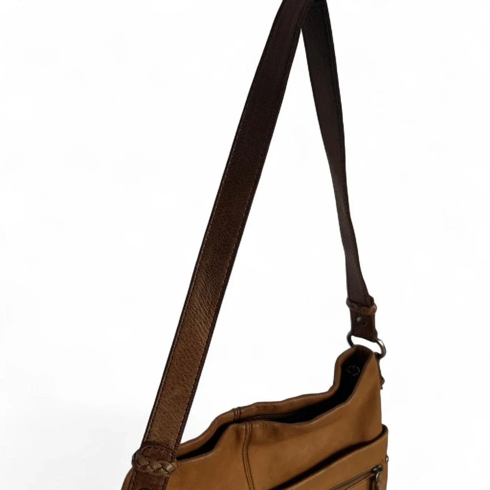 Tan leather shoulder bag with zipper closure, multiple pockets & braided tassel